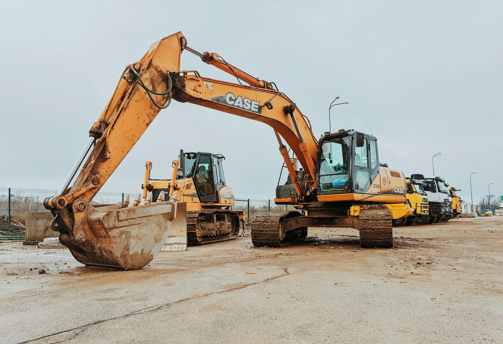 Excavators lined up at an equipment yard, ready for dispatch