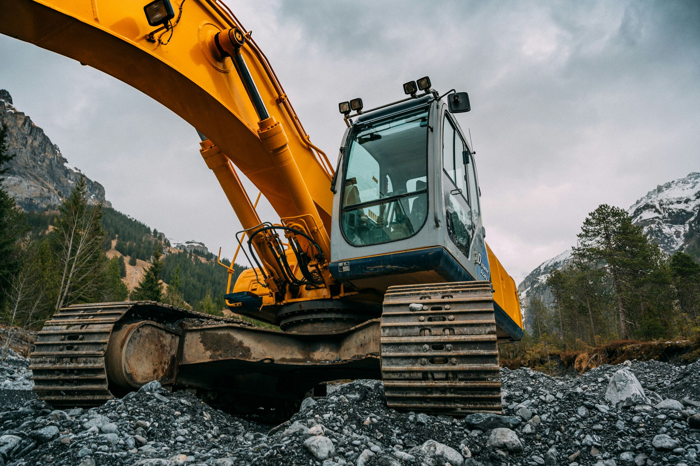 Excavator boom and cab at work on a rocky Ghanaian site